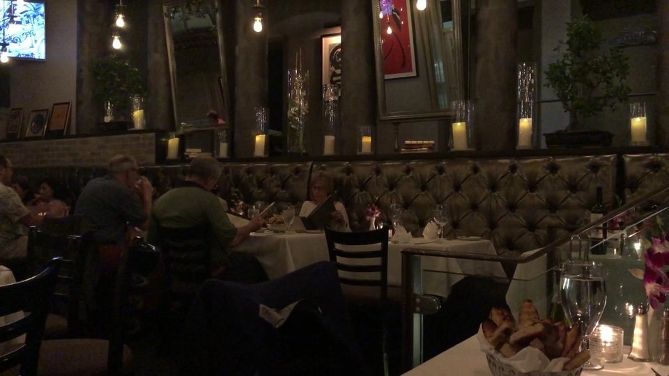 Warm dining room with table service and wine glasses.