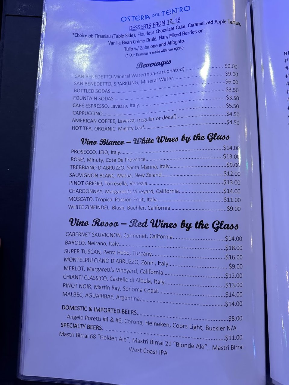 Menu page beside a cocktail glass.